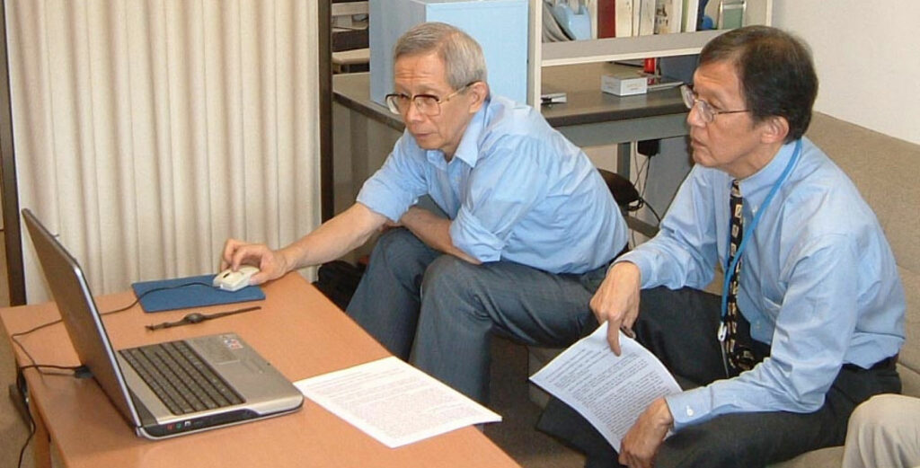 Figura 2: Dr. Aoyagi mostrando seu trabalho em artefato de movimento ao Dr. Byron Aoki, da University of Hawaii (no consultório do autor quando ele era o chefe da UTI do National Center for Child Health and Development em Tóquio, em 2002).