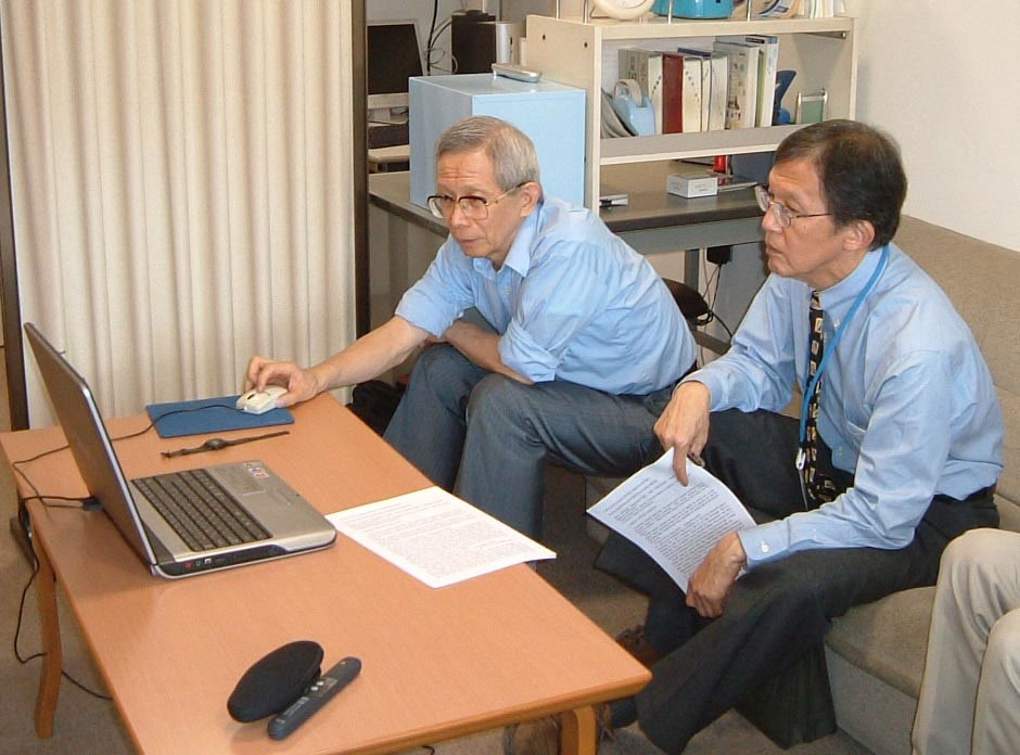 Figure 5: Dr. Aoyagi showing his work to Dr. Byron Aoki of the University of Hawaii<br /> At the author’s office,<br /> Head of the department of anesthesia and ICU<br /> National Center for Child Health and Development, 2002